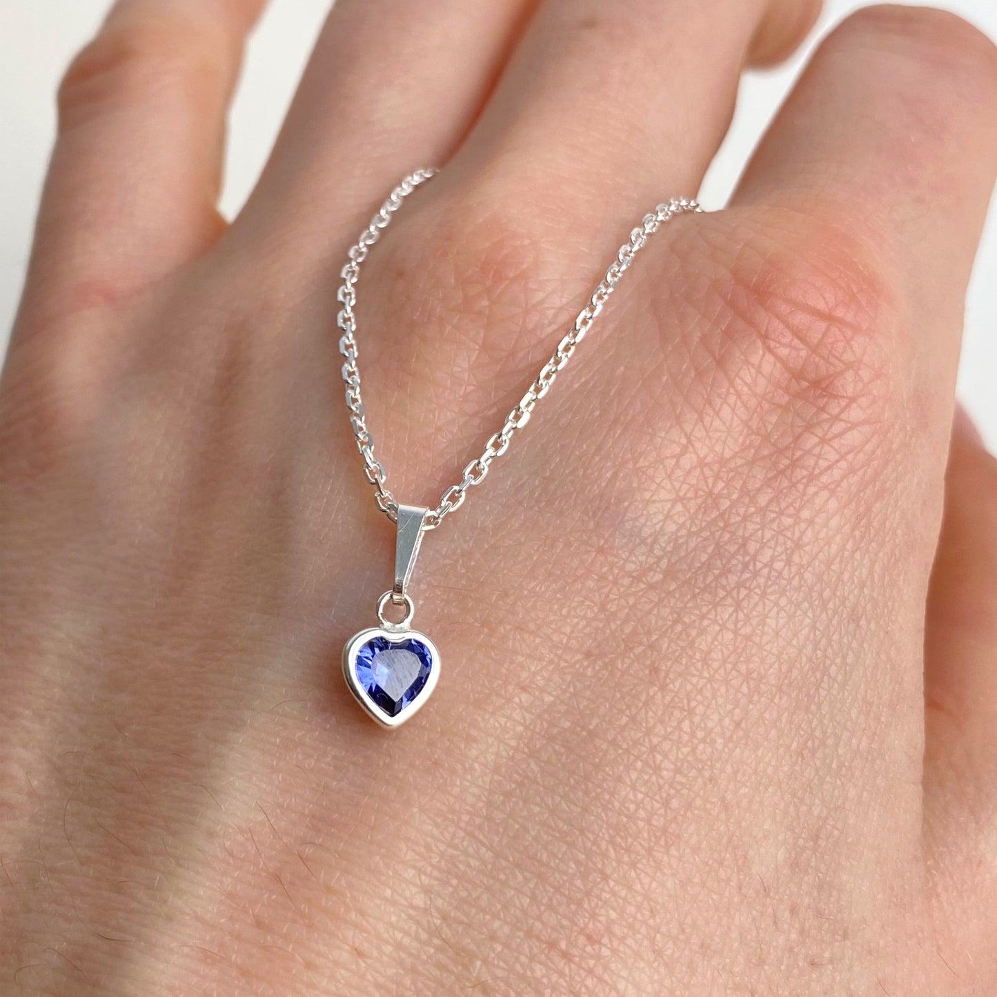 blauer Herz Stein Anhänger als halskette auf hand