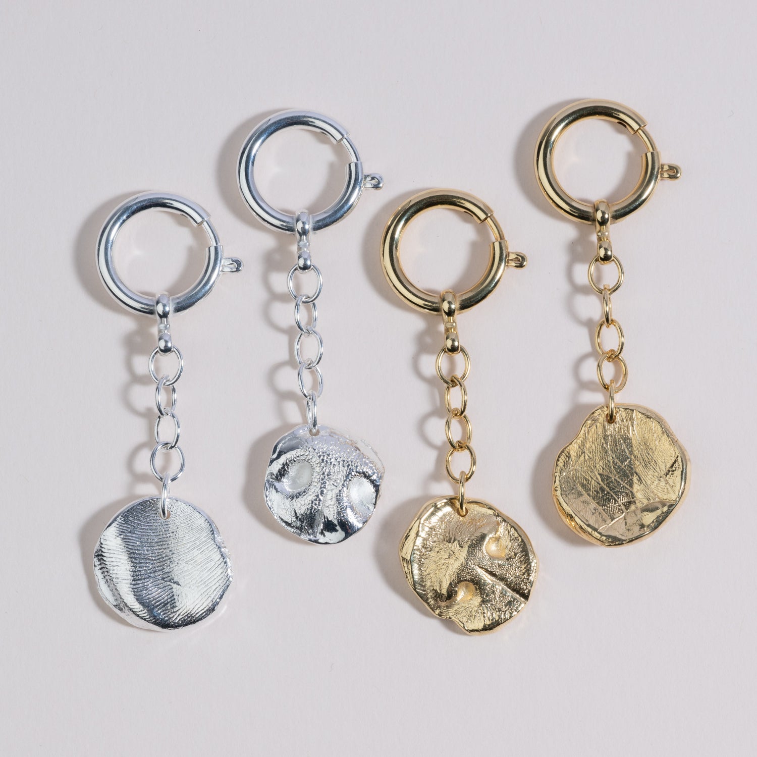 4 verschiene Schlüsselanhänger in je Gold und Silber mit Nasenabdruck in Naturform 